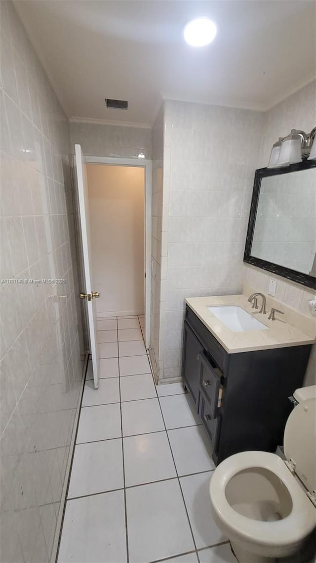 bathroom with tile patterned flooring, vanity, tile walls, and toilet