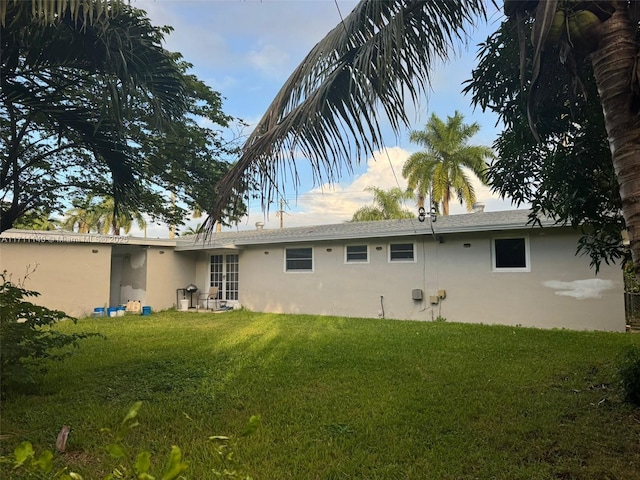 back of house featuring a lawn