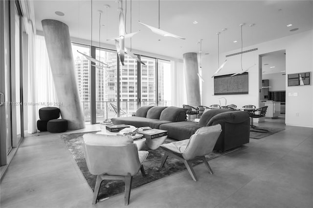 living room featuring floor to ceiling windows and concrete floors