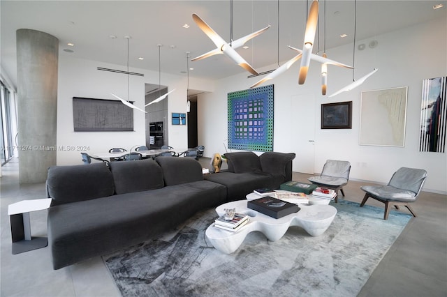 living room with concrete flooring and a high ceiling