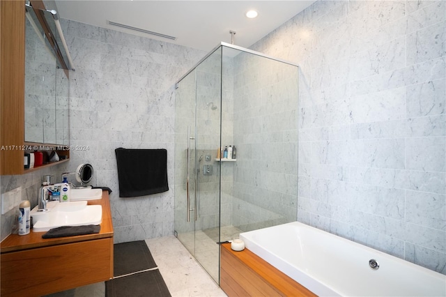 bathroom featuring tile walls and independent shower and bath