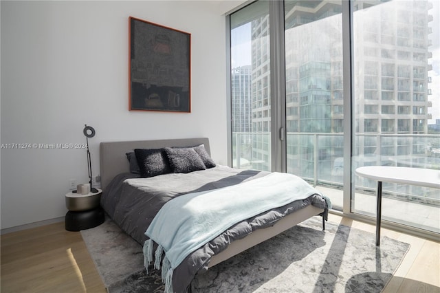 bedroom with access to exterior and wood-type flooring