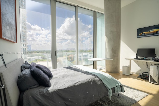 bedroom with multiple windows and hardwood / wood-style floors