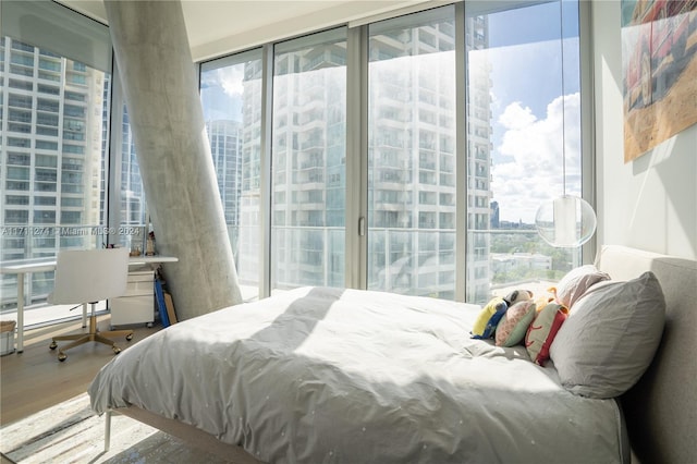 bedroom featuring access to outside, floor to ceiling windows, and hardwood / wood-style flooring