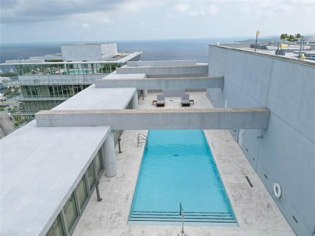 view of swimming pool featuring a water view