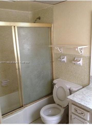 full bathroom featuring vanity, toilet, and enclosed tub / shower combo