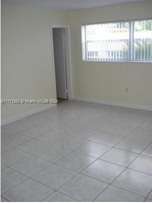 tiled spare room with a healthy amount of sunlight