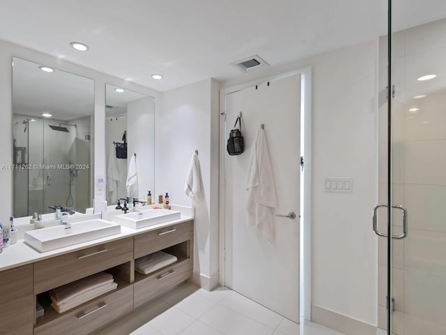 bathroom featuring tile patterned flooring, vanity, and walk in shower