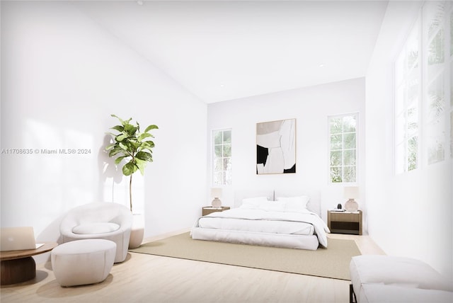 bedroom with hardwood / wood-style flooring, vaulted ceiling, and multiple windows