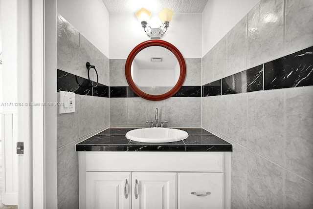 bathroom featuring vanity and tile walls