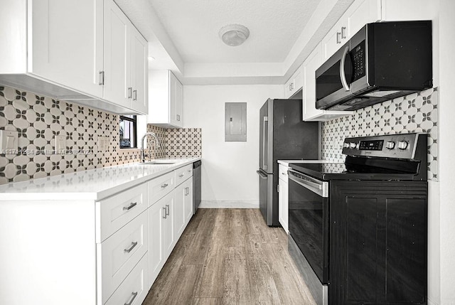 kitchen featuring white cabinetry, sink, electric panel, light hardwood / wood-style floors, and appliances with stainless steel finishes