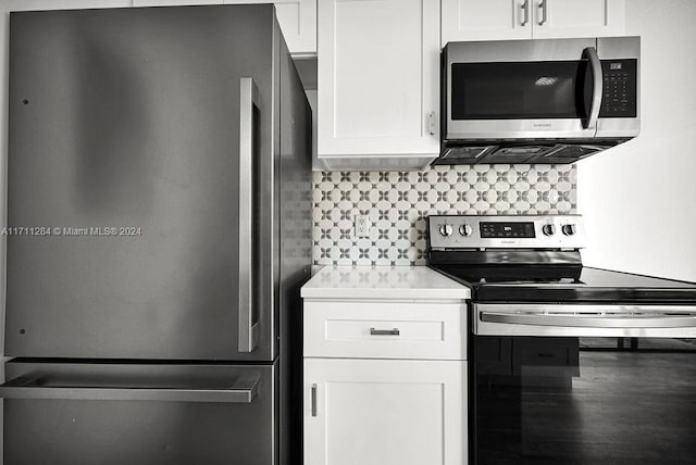 kitchen with decorative backsplash, stainless steel appliances, and white cabinetry