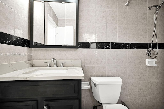 bathroom with vanity, toilet, and tile walls