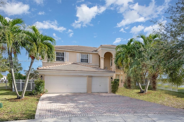 mediterranean / spanish-style home with a front yard and a garage