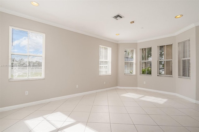 spare room with light tile patterned floors, ornamental molding, and a wealth of natural light