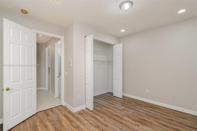 unfurnished bedroom featuring hardwood / wood-style floors and a closet