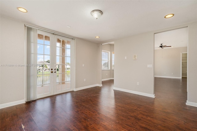 empty room with plenty of natural light, ceiling fan, dark hardwood / wood-style flooring, and french doors