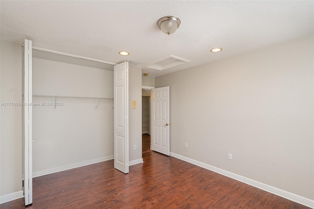 unfurnished bedroom featuring dark wood-type flooring and a closet