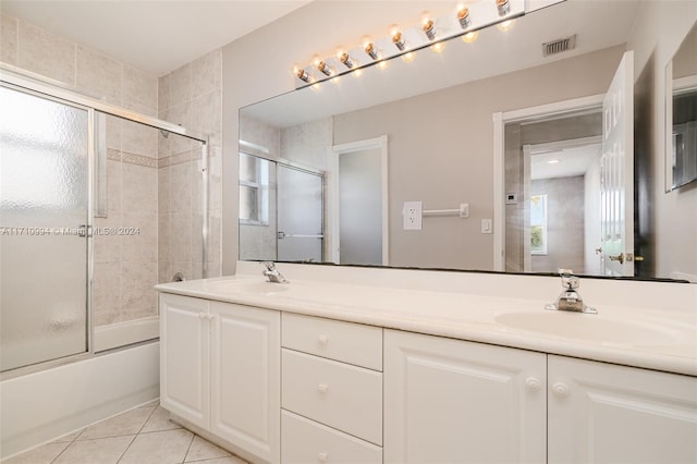 bathroom featuring tile patterned flooring, vanity, and shower / bath combination with glass door