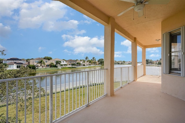 balcony with a water view and ceiling fan