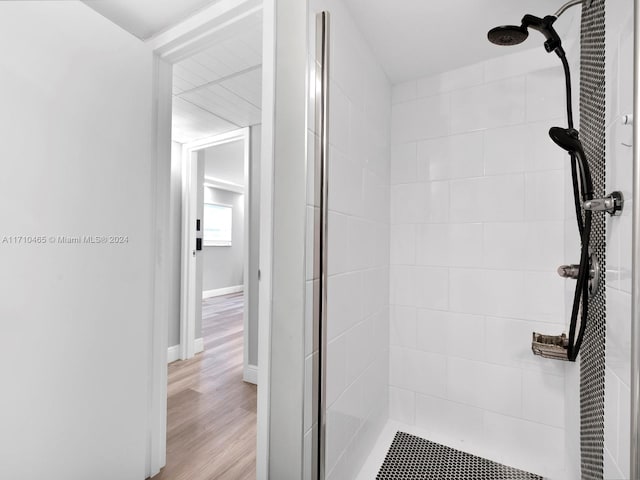 bathroom featuring hardwood / wood-style flooring and tiled shower