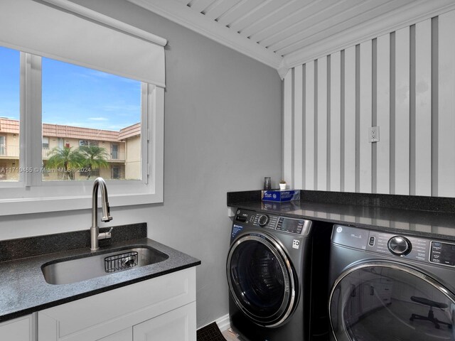 clothes washing area with separate washer and dryer, crown molding, and sink