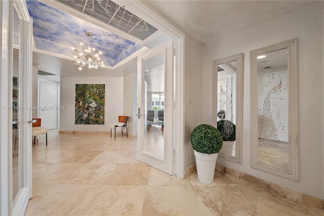 entryway with crown molding and a notable chandelier