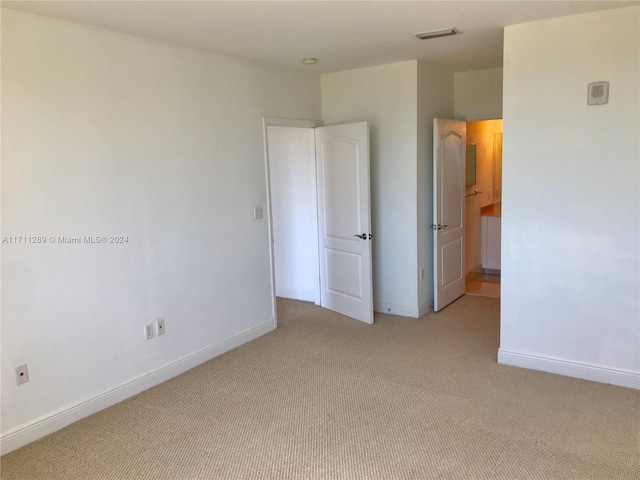 unfurnished bedroom with light colored carpet