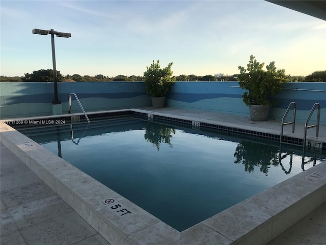 view of pool at dusk