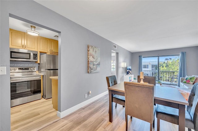 dining space featuring light wood-type flooring