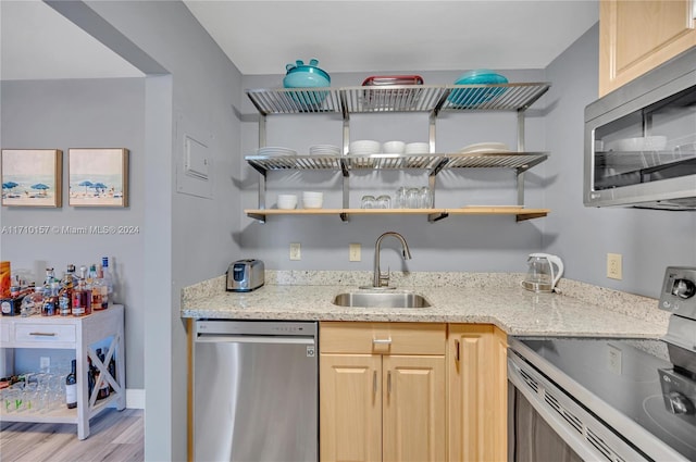 kitchen featuring sink, light wood-type flooring, light brown cabinetry, light stone counters, and stainless steel appliances