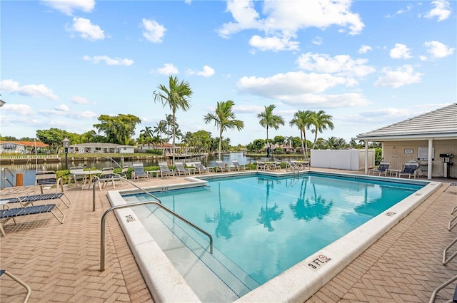 view of swimming pool with a patio and a water view