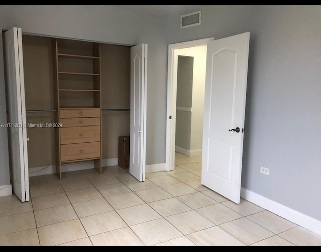 unfurnished bedroom with a closet and light tile patterned flooring