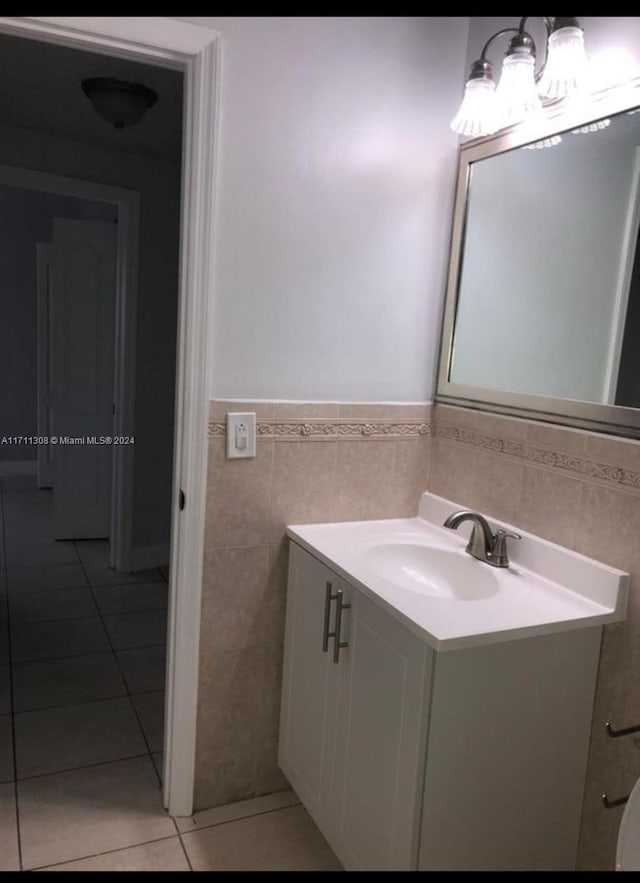 bathroom with tile patterned flooring, vanity, and tile walls