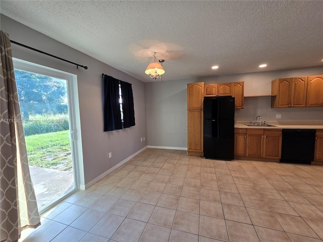 kitchen with sink, light tile patterned floors, black appliances, and a textured ceiling