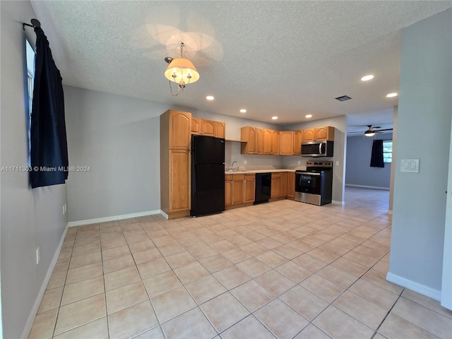 kitchen featuring black appliances, sink, ceiling fan, light tile patterned floors, and a textured ceiling