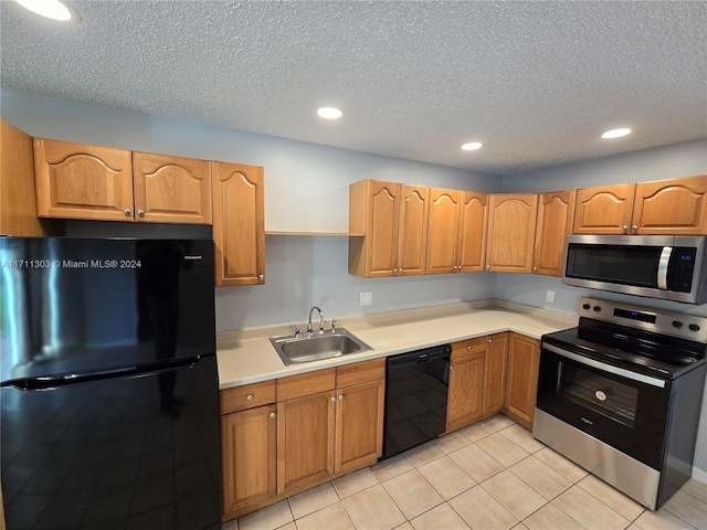 kitchen with sink, light tile patterned flooring, black appliances, and a textured ceiling