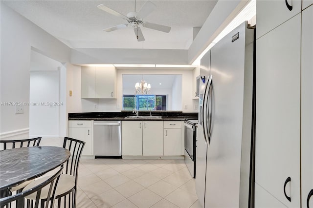 kitchen with white cabinetry, sink, lofted ceiling, ceiling fan with notable chandelier, and appliances with stainless steel finishes