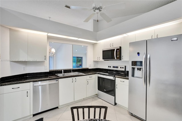 kitchen featuring appliances with stainless steel finishes, dark stone counters, ceiling fan, sink, and white cabinets