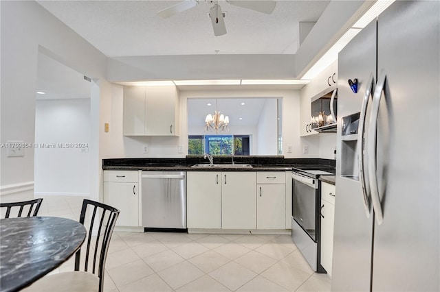 kitchen with sink, stainless steel appliances, pendant lighting, a textured ceiling, and white cabinets