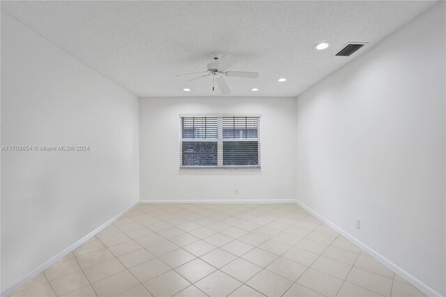 empty room with ceiling fan and a textured ceiling