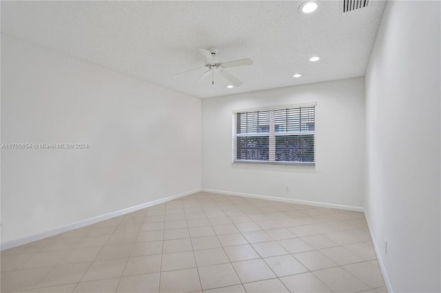 spare room with ceiling fan, light tile patterned floors, and a textured ceiling