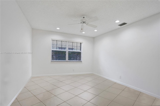 spare room with ceiling fan, light tile patterned floors, and a textured ceiling