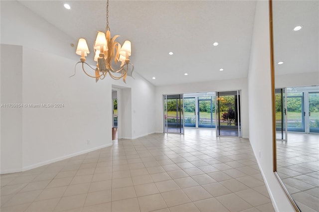 tiled spare room with high vaulted ceiling and a notable chandelier