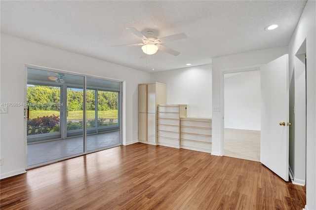 spare room featuring wood-type flooring, a textured ceiling, and ceiling fan