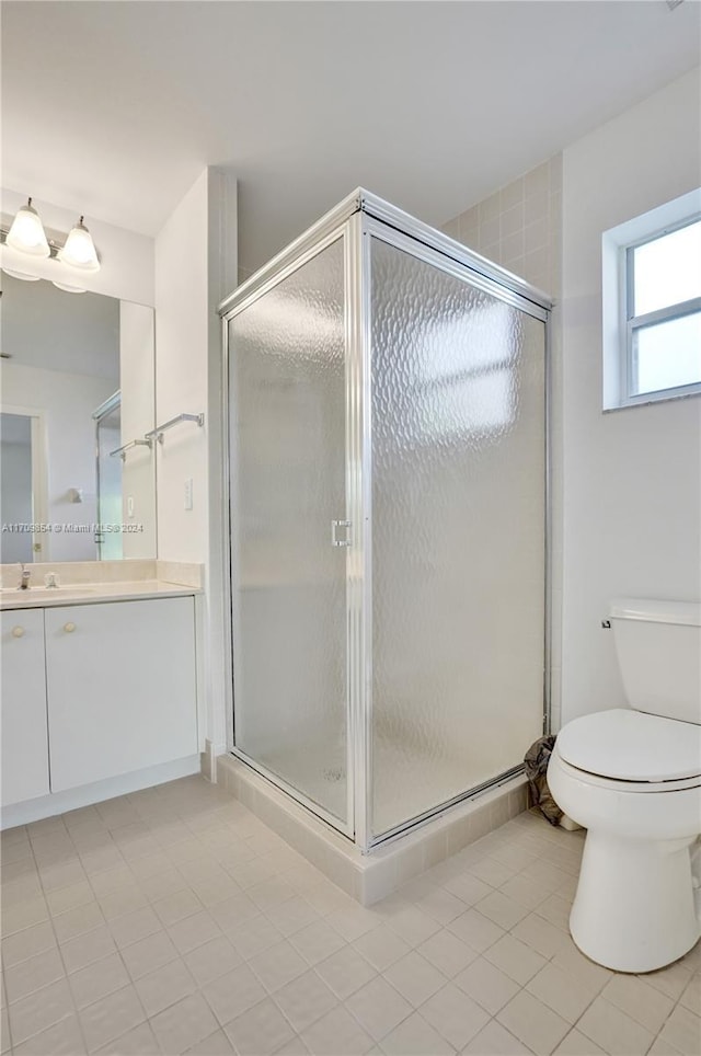 bathroom featuring tile patterned floors, vanity, toilet, and an enclosed shower