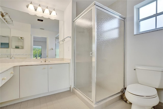 bathroom with tile patterned flooring, vanity, toilet, and a shower with shower door