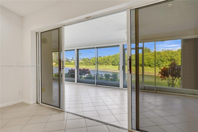 tiled empty room featuring plenty of natural light and a water view