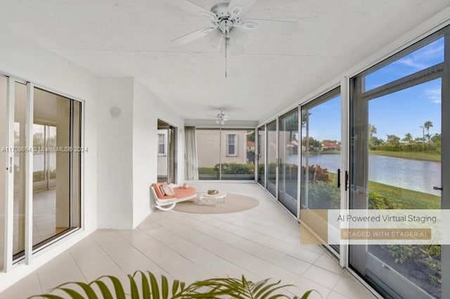 sunroom featuring ceiling fan, a water view, and a wealth of natural light