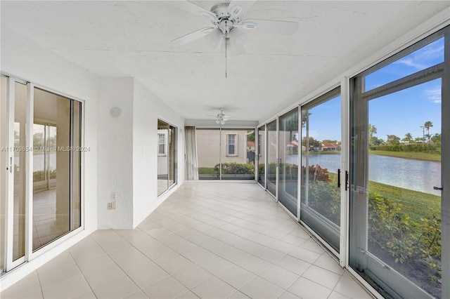 unfurnished sunroom with a water view and ceiling fan